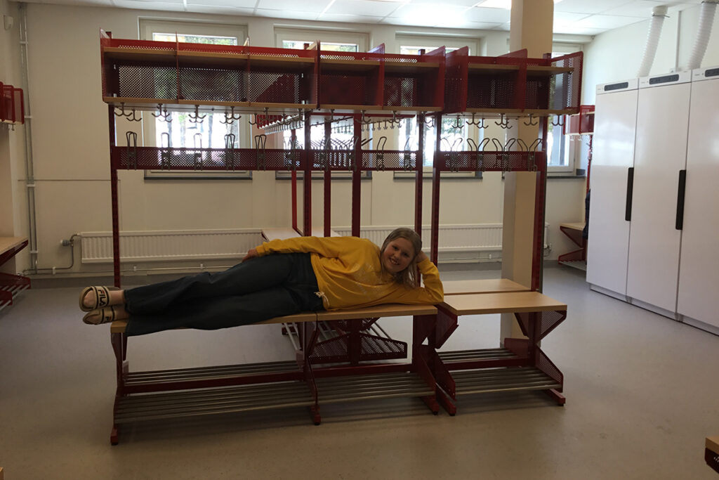 En elev som ligger på en av bänkarna i kapprummet.