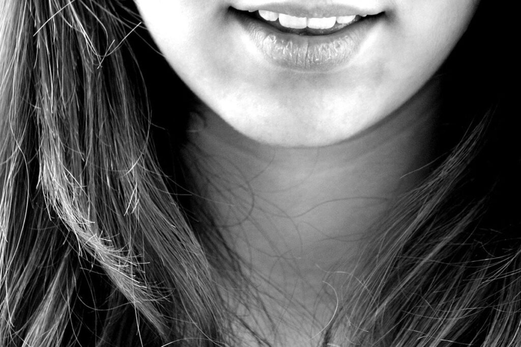 En svartvit närbild på en person som ler.